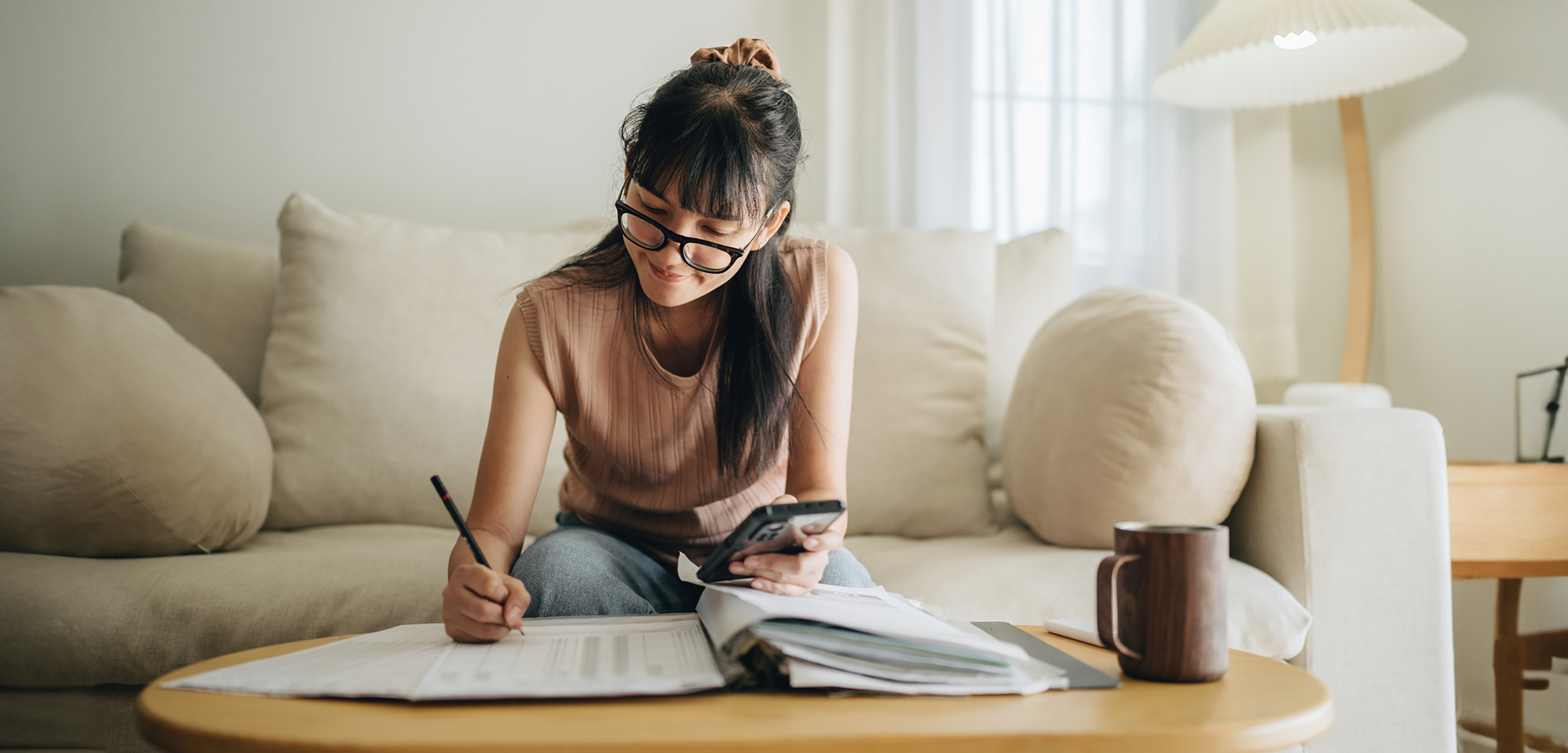 A young woman sitting on her sofa researching share certificate of deposit options